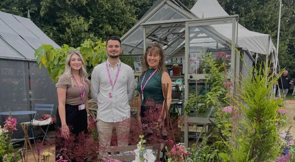 Three members of the Rhino team standing infront of a greenhouse