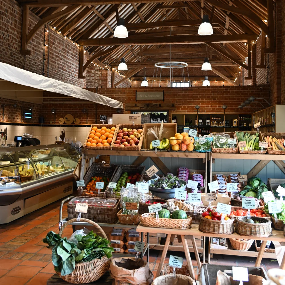 Assortment of fresh fruit, veg and cheeses in a converted barn with exposed wooden beams