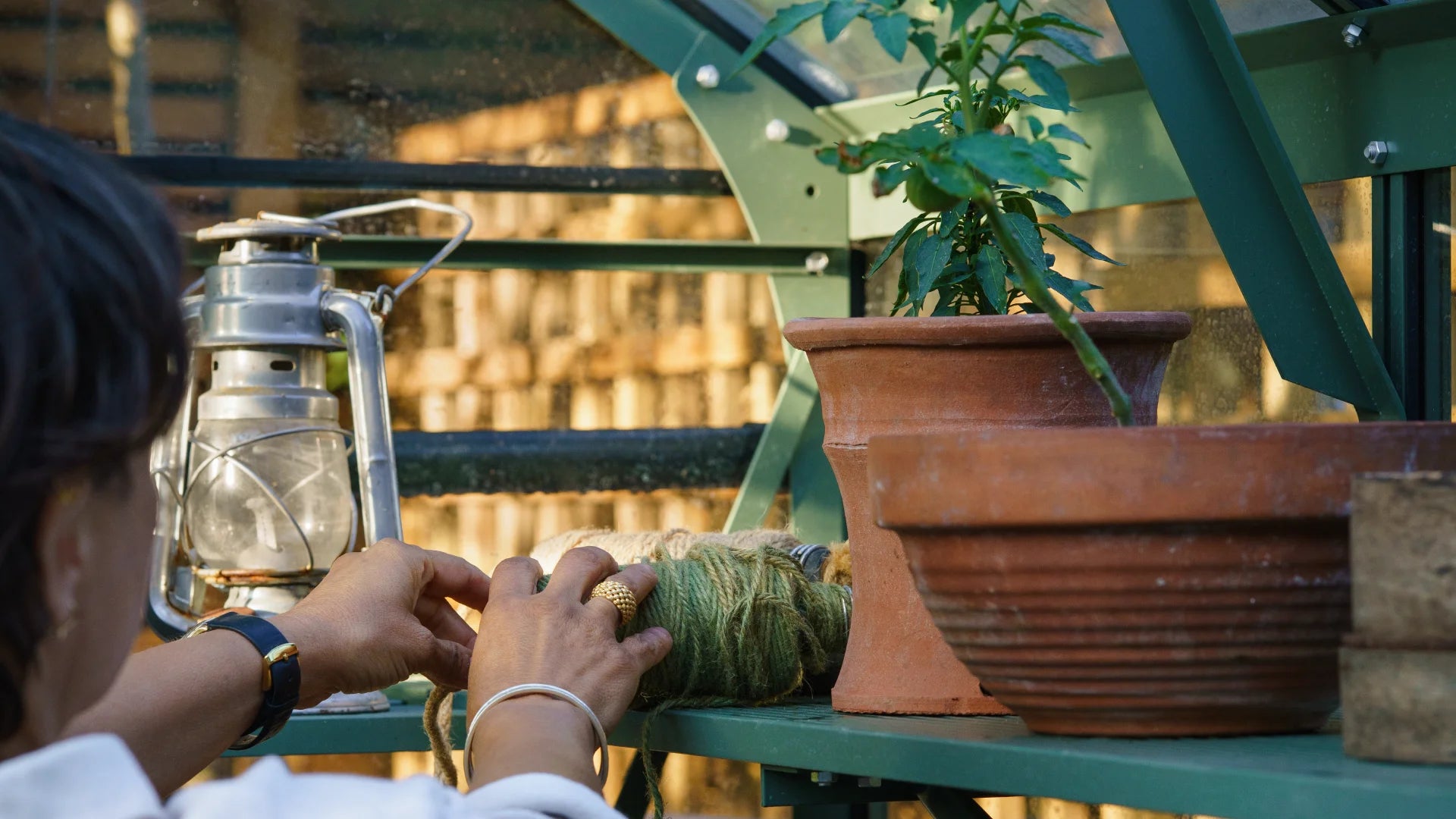 Lady unraveling string inside her greenhouse